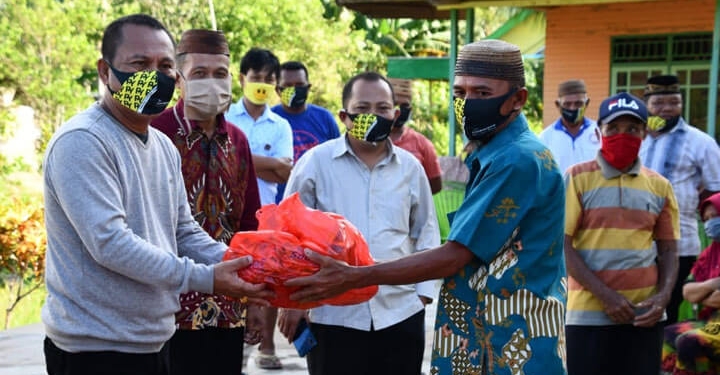Sekretaris Daerah, Ridwan Yasin saat menyalurkan sembako kepada 100 warga penerima bantuan yang berada di Kecamatan Biau, Kabupaten Goronto. (foto.istimewa)