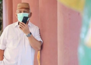 Gubernur Gorontalo Rusli Habibie saat berkomunikasi dengan telepon seluler. (Foto: dok Humas).