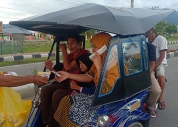 Seorang petugas Dinas Perhubungan Pemprov Gorontalo mencegat pengendara bentor dan penumpangnya yang tidak menggunakan masker di kompleks Center Point, Kabupaten Bone Bolango, Sabtu (12/9/2020). Aksi bagi-bagi masker dan sosialisasi pencegahan covid-19 dilakukan di sela-sela kegiatan Offroad Gubernur Rusli di lokasi yang sama. (Foto: istimewa).