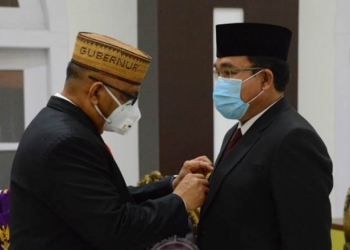 Gubernur Gorontalo Rusli Habibie (kiri) menyematkan pin kepada Pjs Bupati Gorontalo Mitran Tuna usai dikukuhkan di Aula Rumah Jabatan, Jumat malam (25/9/2020). Sekretaris DPRD itu dikukuhkan berdasarkan SK Mendagri Nomor 131.75-3036 Tahun 2020 yang aktif mulai tanggal 26 September hingga 5 Desember 2020. (Foto: Isam-Humas).