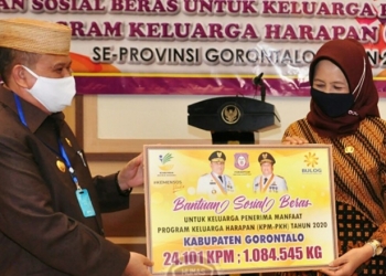 Wagub Gorontalo H. Idris Rahim (kiri) menyerahkan secara simbolis Bantuan Sosial Beras kepada Sekda Kabupaten Gorontalo di aula rumah jabatan Wagub, Selasa (15/9/2020). Kabupaten Gorontalo menerima Bantuan Sosial Beras sebanyak 1.084.545 kilogram untuk 24.101 KPM. (Foto : Haris – Humas)