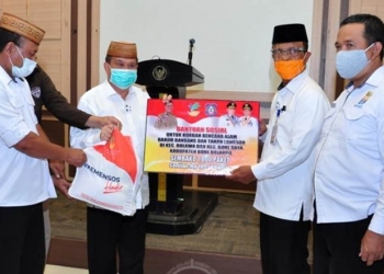 Wagub Gorontalo H. Idris Rahim (kedua kiri), menyerahkan secara simbolis bansos untuk korban bencana banjir bandang dan tanah longsor kepada Sekda Bone Bolango, Ishak Ntoma, di aula rumah jabatan Wagub, Rabu (23/9/2020). (Foto : Haris – Humas)
