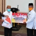 Wagub Gorontalo H. Idris Rahim (kedua kiri), menyerahkan secara simbolis bansos untuk korban bencana banjir bandang dan tanah longsor kepada Sekda Bone Bolango, Ishak Ntoma, di aula rumah jabatan Wagub, Rabu (23/9/2020). (Foto : Haris – Humas)