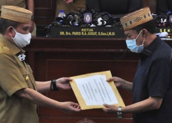 Wagub Gorontalo H. Idris Rahim (kiri) menyerahkan dokumen Ranperda penegakan disiplin protokol kesehatan kepada Ketua DPRD Provinsi Gorontalo, Paris R.A Jusuf, untuk dibahas lebih lanjut sesuai mekanisme dewan pada Rapat Paripurna ke-32, Senin (21/9/2020). (Foto : Haris – Humas)