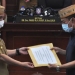 Wagub Gorontalo H. Idris Rahim (kiri) menyerahkan dokumen Ranperda penegakan disiplin protokol kesehatan kepada Ketua DPRD Provinsi Gorontalo, Paris R.A Jusuf, untuk dibahas lebih lanjut sesuai mekanisme dewan pada Rapat Paripurna ke-32, Senin (21/9/2020). (Foto : Haris – Humas)
