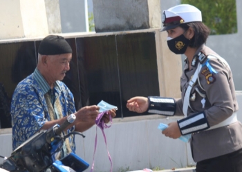 Petugas Lalu Lintas Polda Gorontalo memberikan masker kepada pengendara yang tak mengenakan masker dalam operasi Zebra Otanaha 2020, Senin (26/10/2020). (Humas Polda Gorontalo)