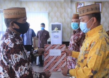 Sekretaris Daerah Provinsi Gorontalo Darda Daraba (kiri) menyerahkan SK Pelaksana tugas  (Plt) Kepala Badan Keuangan Provinsi Gorontalo kepada Danial Ibrahim di ruang Huyula Kantor Gubernur, Jumat (2/10/2020). (Foto: Nova – Humas)