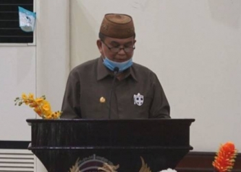 Wakil Gubernur Gorontalo, H. Idris Rahim dalam membacakan pendapat akhir Gubernur pada Rapat Paripurna dalam rangka Pembicaraan Tingkat II terhadap Ranperda Provinsi Gorontalo tentang Penerapan Disiplin dan Penegakan Hukum Protokol Kesehatan sebagai Upaya Pencegahan dan Pengendalian Corona Virus Disease 2019 (Covid 19) di ruang sidang DPRD Provinsi Gorontalo, Selasa (06/10/2020). Foto : Fadly – Humas