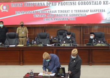 Gubenrur Gorontalo, Rusli Habibie, bersama Ketua DPRD Provinsi Gorontalo, Paris R.A Jusuf, menandatangani berita acara persetujuan Ranperda APBD 2021.(putra/gopos)