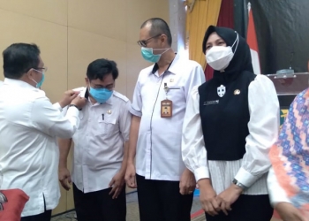 Wali Kota Gorontalo, Marten Taha mengenakan Pin penghargaan ke Sembilan ASN Pemkot Gorontalo yang berlangsung di Hotel Grand Q Kota Gorontalo, Rabu (11/11/2020). (F.Ramlan/gopos).