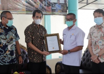 Deputi Direksi BPJS Kesehatan Wilayah Sulutenggomalut, Chandra Nurcahyo memberikan penghargaan kepada Syarif Mbuinga