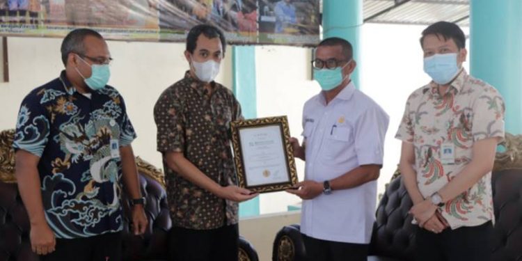 Deputi Direksi BPJS Kesehatan Wilayah Sulutenggomalut, Chandra Nurcahyo memberikan penghargaan kepada Syarif Mbuinga