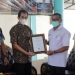 Deputi Direksi BPJS Kesehatan Wilayah Sulutenggomalut, Chandra Nurcahyo memberikan penghargaan kepada Syarif Mbuinga
