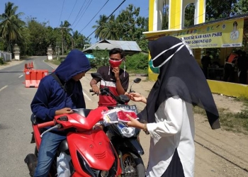 Selain menyosialisikan gerakan 3M, Dinas Kesehatan Provinsi Gorontalo bersama Puskesmas Atinggola turut membagikan masker dan hand sanitizer kepada masyarakat di wilayah perbatasam antara Gorontalo dan Provinsi Sulawesi Utara, Rabu (4/11/2020) foto: istimewa