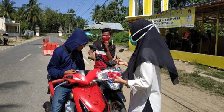 Selain menyosialisikan gerakan 3M, Dinas Kesehatan Provinsi Gorontalo bersama Puskesmas Atinggola turut membagikan masker dan hand sanitizer kepada masyarakat di wilayah perbatasam antara Gorontalo dan Provinsi Sulawesi Utara, Rabu (4/11/2020) foto: istimewa