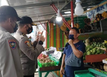 Kabag Ops Polres Gorontalo Kota, Kompol Lufti Amir SIK membagikan masker kepada pelaku usaha sekaligus mengingatkan mereka agar senantiasa patuh terhadap protokol kesehata, Senin (16/11/2020) (muhajir/gopos)