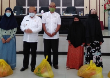 Wali Kota Gorontalo, Marten Taha bersama Ketua Baznas Kota Gorontalo, Marzuki Pakaya, menyerahkan bantuan paket sembako untuk ibu dan janda dhuafa.(sari/gopos)