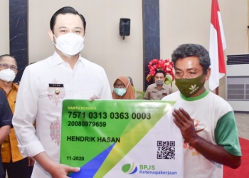 Wikil Wali Kota Gorontalo, memberikan secara simbolis kartu jaminan sosial ketenagakerjaan kepada pekerja formal dan informal. Foto: Istimewa.