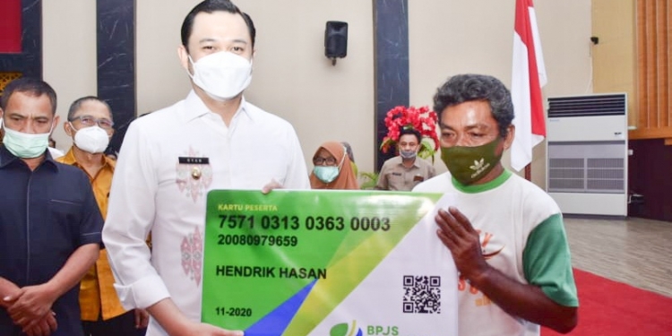Wikil Wali Kota Gorontalo, memberikan secara simbolis kartu jaminan sosial ketenagakerjaan kepada pekerja formal dan informal. Foto: Istimewa.