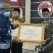 Asisten I Setda Provinsi Gorontalo, Syukri J Botutihe, menyerahkan piagam penghargaan Kanwil Kemenkumham Gorontalo kepada Bupati Gorontalo, Nelson Pomalingo, Senin (14/12/2020). (istimewa)