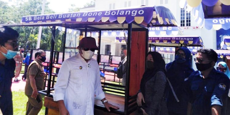 Bupati Bone Bolango, Hamim Pou, dan Kadis Perindagkum Bone Bolango Imran Bagu, menyerahkan secara simbolis bantuan Gerobak kepada para pelaku usaha. (Rahman/gopos)