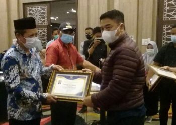 Bupati Hamim Pou, saat memberikan piagam penghargaan kepada 11 desa dengan kinerja pengelolaan keuangan terbaik. Foto: Indra/gopos.