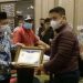 Bupati Hamim Pou, saat memberikan piagam penghargaan kepada 11 desa dengan kinerja pengelolaan keuangan terbaik. Foto: Indra/gopos.