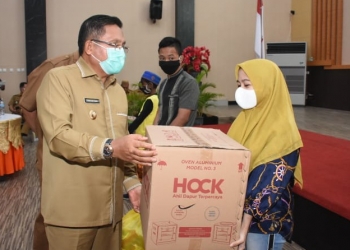 Wali Kota Gorontalo, Marten Taha menyerahkan bantuan sosial kepada pelaku usaha di Kota Gorontalo. Foto: Istimewa.