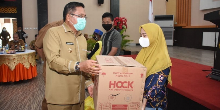 Wali Kota Gorontalo, Marten Taha menyerahkan bantuan sosial kepada pelaku usaha di Kota Gorontalo. Foto: Istimewa.