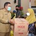 Wali Kota Gorontalo, Marten Taha menyerahkan bantuan sosial kepada pelaku usaha di Kota Gorontalo. Foto: Istimewa.