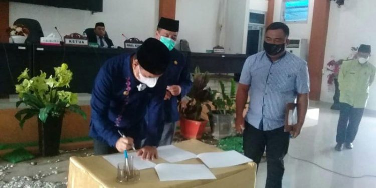 Bupati Bone Bolango saat menandatangani surat persetujuan Ranperda menjadi Perda (Indra/Gopos)