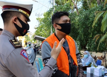 Salah seorang pelanggar protokol kesehatan diberi sanksi menghafal pancasila. (dok. Humas Polda Gorontalo)