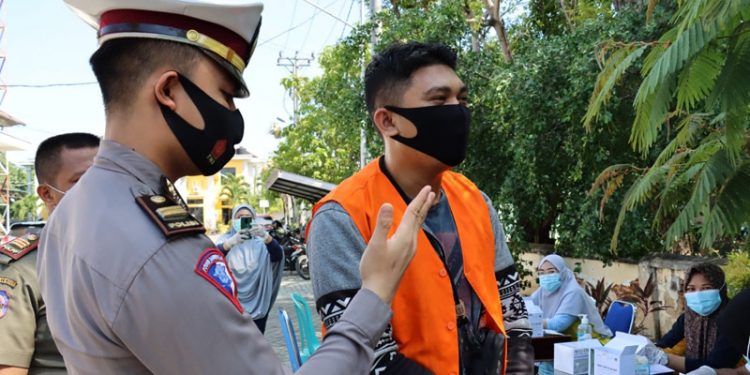 Salah seorang pelanggar protokol kesehatan diberi sanksi menghafal pancasila. (dok. Humas Polda Gorontalo)