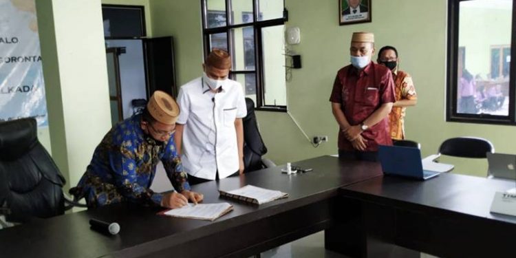 Anggota DPRD Provinsi Gorontalo, Adnan Entengo bersama Rektor UNU Gorontalo, Ridwan Tohopi menandatangani MoU antara DPRD Provinsi Gorontalo bersama UNU Goronntalo, Rabu (9/12/2020). (foto: istimewa)