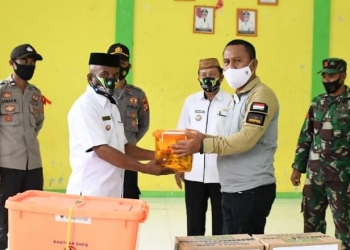 Sekda Gorut, Ridwan Yasin saat menyerahkan bantuan kepada warga yang terdampak banjir di 5 desa yang ada di Kecamatan Biau, Rabu (24/12/2020).(foto.arif/hms)