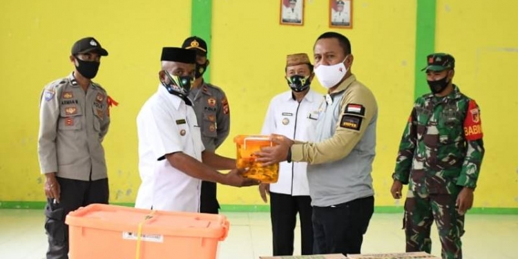 Sekda Gorut, Ridwan Yasin saat menyerahkan bantuan kepada warga yang terdampak banjir di 5 desa yang ada di Kecamatan Biau, Rabu (24/12/2020).(foto.arif/hms)