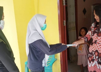 Mahasiswa Sosiologi UNG, membagikan masker gratis ke masyarakat Kecamatan Suwawa. Foto: Istimewa