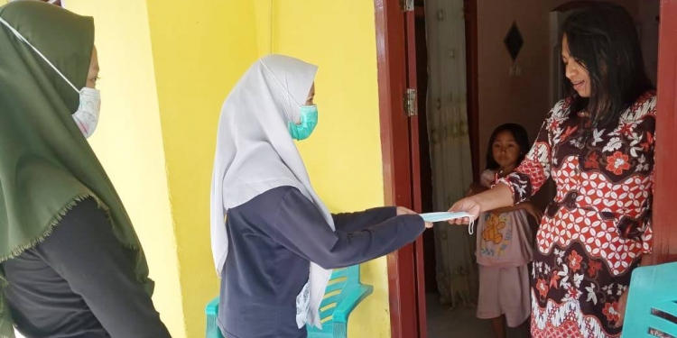 Mahasiswa Sosiologi UNG, membagikan masker gratis ke masyarakat Kecamatan Suwawa. Foto: Istimewa