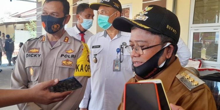 Bupati Gorontalo Utara, Indra Yasin saat diwawancarai oleh sejumlah media pada kegiatan pemusnahan miras jenis cap tikus, di Polres Gorontalo Utara.(foto.isno/gopos)