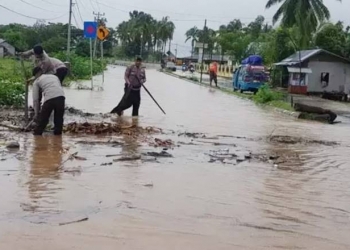 Tim SAR Brimob Gorontalo melakukan pembersihan sampah ranting pohon dan dedaunan untuk mengurangi ketinggian banjir yang merendam Trans Sulawesi di Desa Molingkapoto, Kecamatan Kwandang, Kabupaten Gorontalo, Senin (2/3/2020). (istimewa)