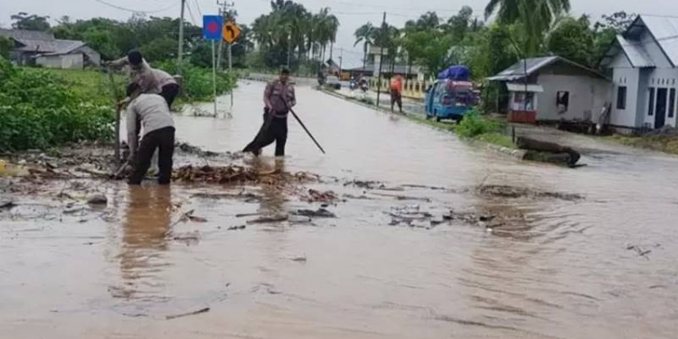 Tim SAR Brimob Gorontalo melakukan pembersihan sampah ranting pohon dan dedaunan untuk mengurangi ketinggian banjir yang merendam Trans Sulawesi di Desa Molingkapoto, Kecamatan Kwandang, Kabupaten Gorontalo, Senin (2/3/2020). (istimewa)