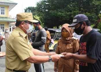 Wali Kota Gorontalo, Marten Taha saat memberikan bantuan kepada para pengemudi bentor di Kota Gorontalo. Foto: Istimewa.