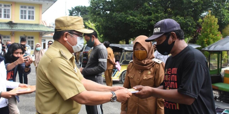 Wali Kota Gorontalo, Marten Taha saat memberikan bantuan kepada para pengemudi bentor di Kota Gorontalo. Foto: Istimewa.