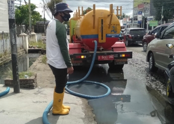 Penyedotan genangan air di perempatan Jl. Andalas dan Jl. Tondano, Kecamatan Sipatana, Kota Gorontalo, Selasa (5/1/2021).