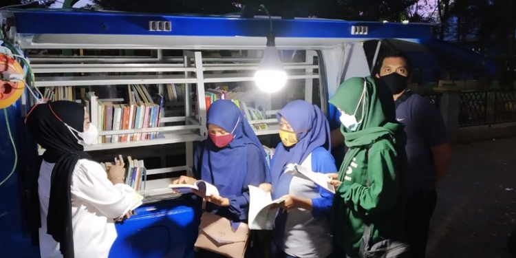 PERPUSTAKAAN KELILING - Beberapa pelajar sedang menikmati bacaan buku di Perpustakaan Keliling Kota Gorontalo. Rabu (20/1/2021). (Foto Istimewa)