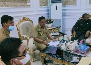 RAKOREV 2020 - Walikota Gorontalo, Marten Taha saat mengikuti Rapat Koordinasi dan Evaluasi (Rakorev) APBD/APBN Triwulan IV T.A 2020 secara vertual di Rudis Walikota Gorontalo, Selasa (19/1/2021). (Foto: Ari/Gopos)