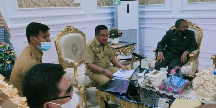 RAKOREV 2020 - Walikota Gorontalo, Marten Taha saat mengikuti Rapat Koordinasi dan Evaluasi (Rakorev) APBD/APBN Triwulan IV T.A 2020 secara vertual di Rudis Walikota Gorontalo, Selasa (19/1/2021). (Foto: Ari/Gopos)