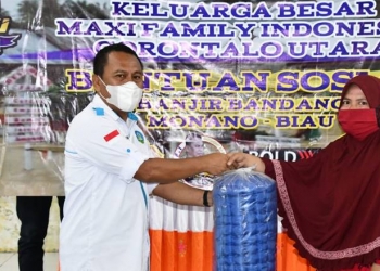 Sekda Gorut, Ridwan Yasin menyerahkan bantuan kepada warga yang terdampak banjir di Kecamatan Monano, Kabupaten Gorontalo Utara. (foto.arif/hms)