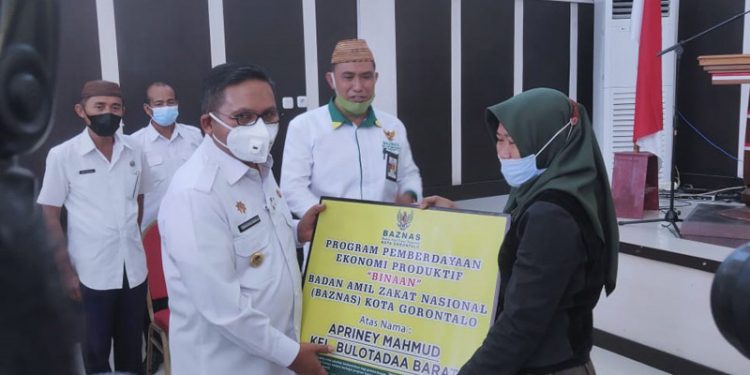 MODAL USAHA - Wali Kota Gorontalo saat memberikan bantuan modal usaha untuk 50 orang pertama secara simbolis di Aula Kantor Wali Kota Gorontalo, Rabu (24/2/2021)