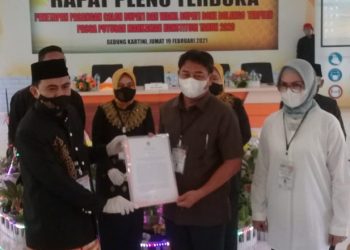 PENETAPAN PEMENANG - Komisi Pemilihan Umum (KPU) Bone Bolango menyerahkan SK penetapan Pemenang Pilkada 2020 kepada pasangan Hamim Pou-Merlan Uloli. (Indra/gopos)